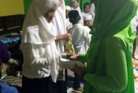 Aidah (kanan) memberikan santunan pada anak yatim. (Foto Dok.Ist)