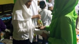 Aidah (kanan) memberikan santunan pada anak yatim. (Foto Dok.Ist)