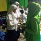 Aidah (kanan) memberikan santunan pada anak yatim. (Foto Dok.Ist)