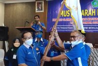 Hadi Sutjipto menerima bendera pataka KORMI Kab. Sidoarjo dari ketua sidang Muskab  