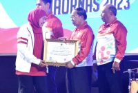 Gubernur Khofifah (kiri) menyerahkan penghargaan Pembina Olahraga Dari Unsur Perorangan kepada MG. Hadi Sutjipto (2 kanan)