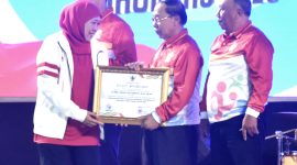 Gubernur Khofifah  (kiri) menyerahkan penghargaan Pembina Olahraga Dari Unsur Perorangan kepada MG. Hadi Sutjipto (2 kanan)