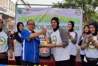 Nurkhasanah, Ketua Markandeya Yoga Indonesia Cabang Sidoarjo menerima nasi tumpeng pertama dari Ketua Umum KORMI Kabupaten Sidoarjo MG Hadi Sutjipto 